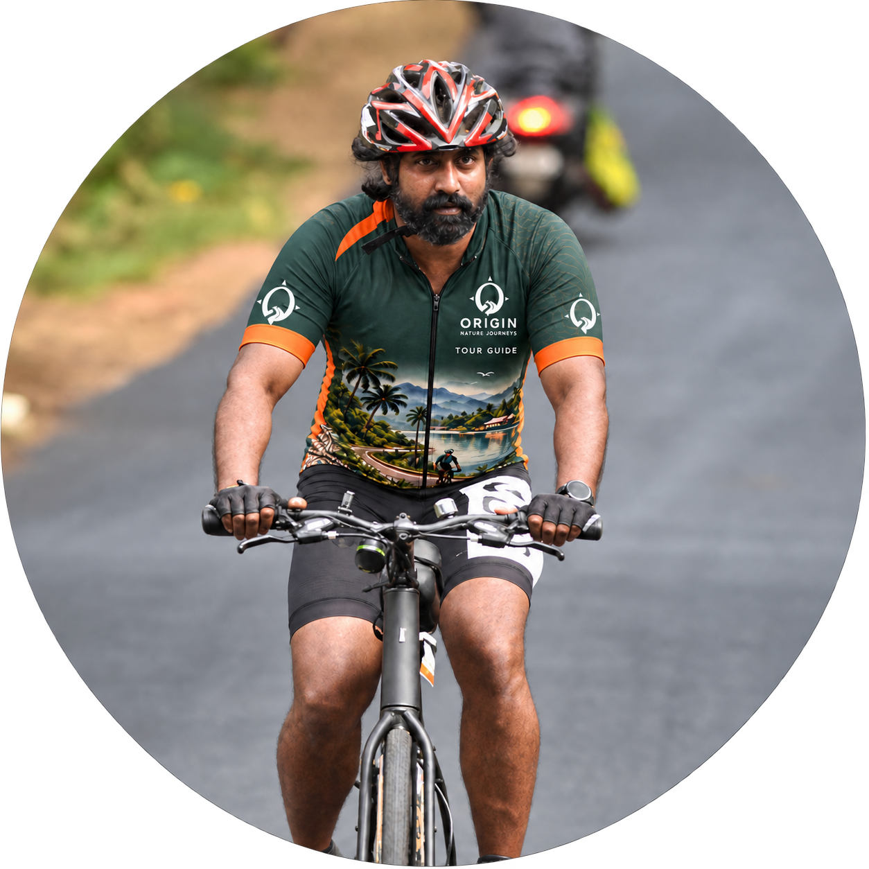 Sujith Sudhan cycling in an Origin Nature Journeys tour guide jersey